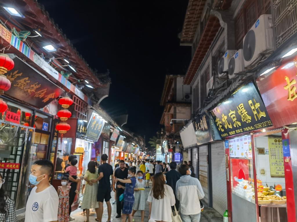 游人们在济南特色老街芙蓉街品尝各种特色美食,感受城市夜晚烟火气