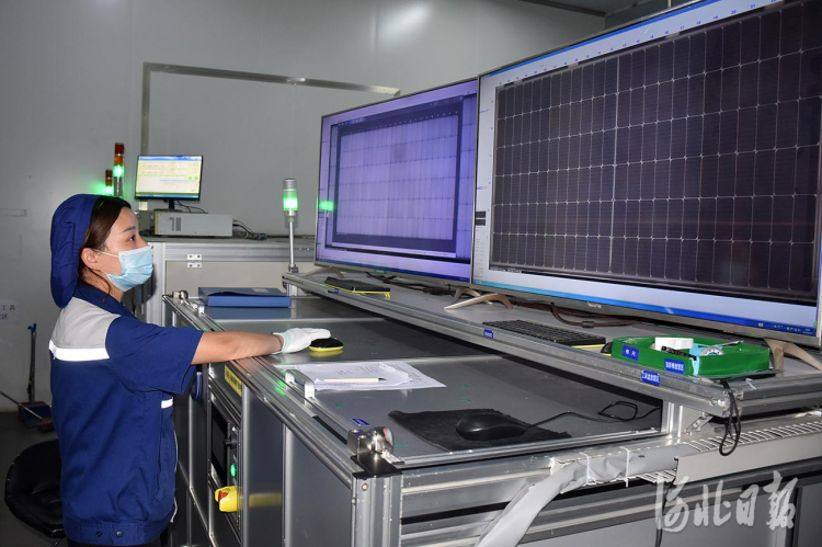 晶澳（邢台）太阳能有限公司工人正在对光伏组件的电池片进行扫描检查。