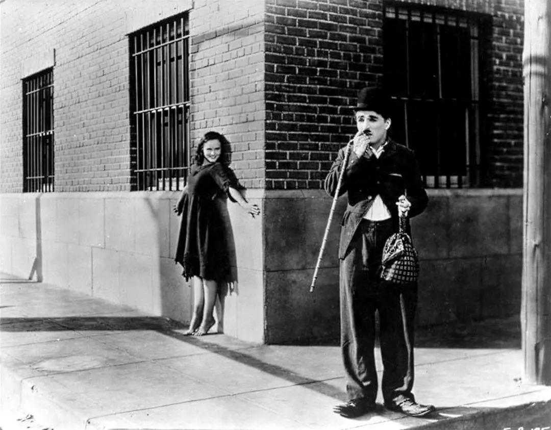 1936年，《摩登时代》，讲述了一个受尽压榨的工人与流浪女的爱情故事，卓别林饰演的是工人夏尔洛