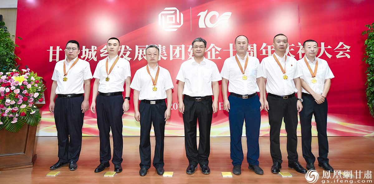 甘肃省城乡发展投资集团有限公司党委书记、董事长王明寿（中）为“企业开拓奉献者”和“光荣在企十周年”获奖人员颁奖 杨艺锴 摄