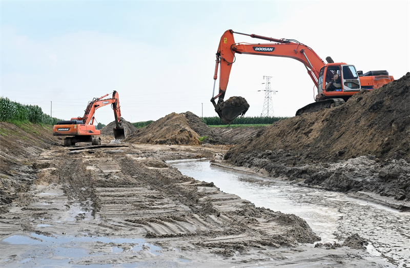 8月5日,工人在昌黎县新集镇境内的引滦河水灌渠清淤现场施工.