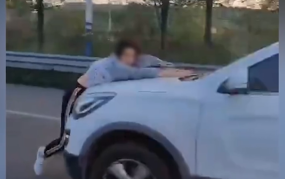 网传视频截图,白色车辆顶着一名女子行驶