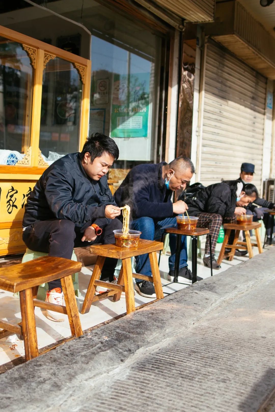 没座的食客干脆在店门口坐一排扎牛大，是兰州的一道风景。摄影/严肃