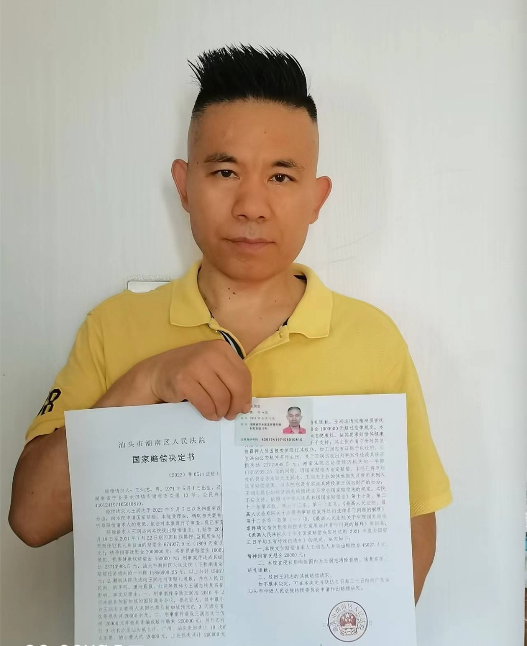 王润志手持国家赔偿决定书。