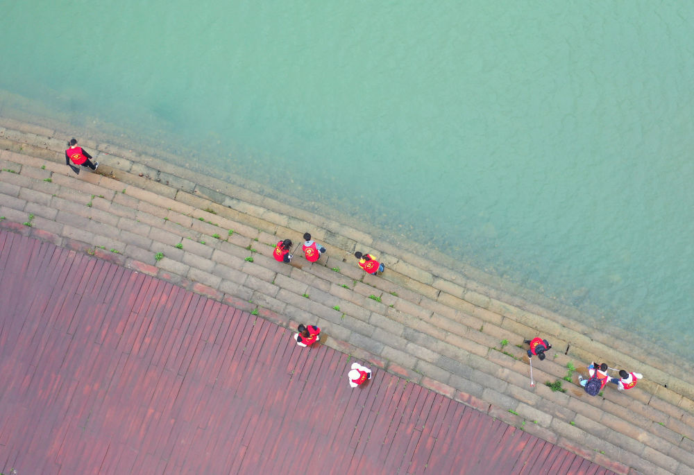 青年志愿者在湖南省衡阳市湘江岸边捡拾垃圾（2021年3月21日摄）。新华社发（曹正平摄）
