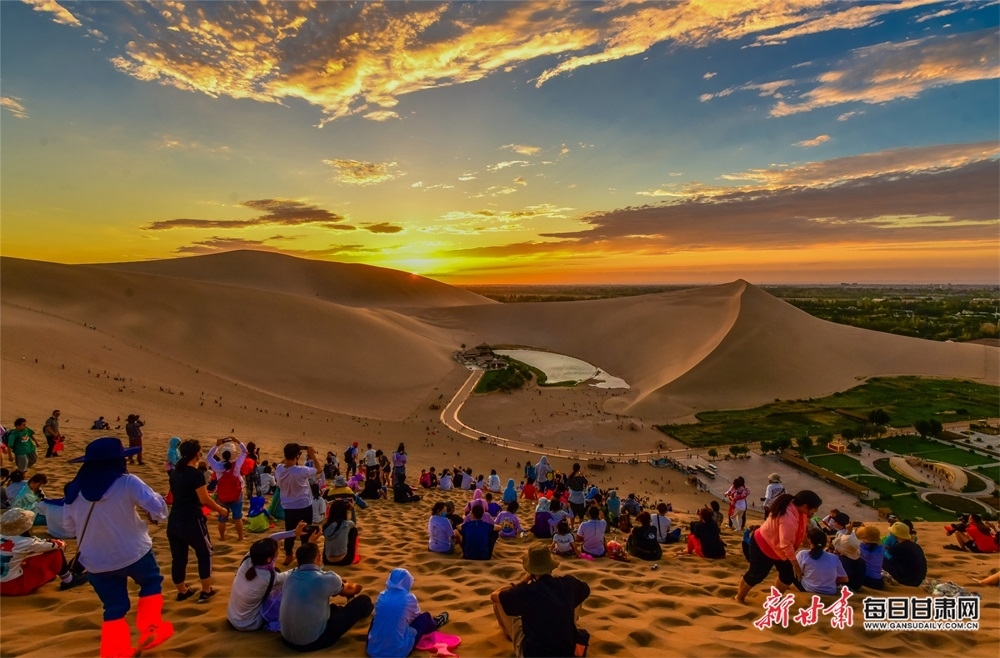 8月7日，游客登上鸣沙山观赏大漠落日壮美景象。