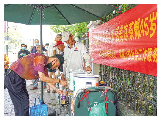 ▲等公交的市民在接凉茶（8月17日摄）。新华社记者殷晓圣摄