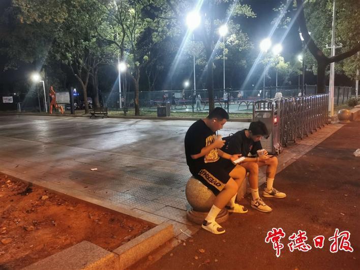 路边喝冷饮聊天的年轻人。