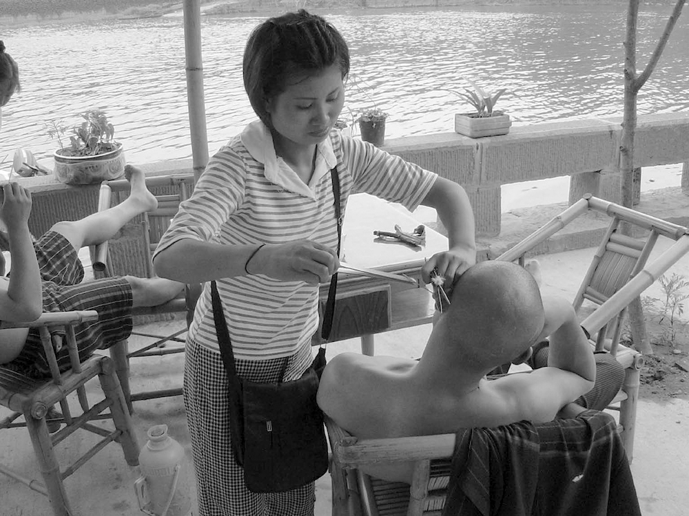 一位女挖耳匠正在给顾客服务。王笛摄于2003年夏。