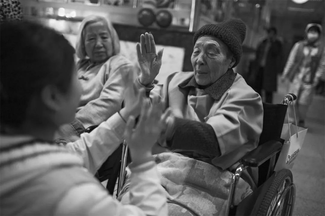 2008年，北京松堂临终关怀医院里，一名护士与老人拍手玩着互动小游戏（图 | ICphoto ）