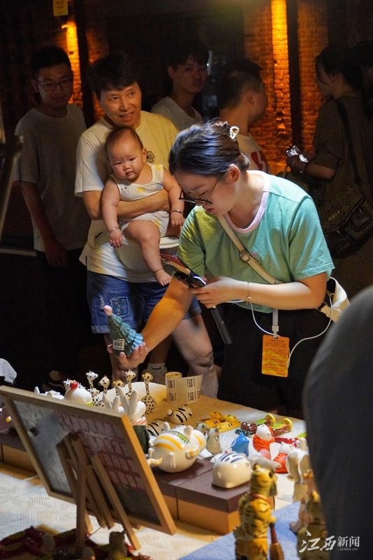 年轻人正在景德镇陶溪川创意集市内直播推介瓷器，无法到访的外地游客可沉浸式“云赶集”。