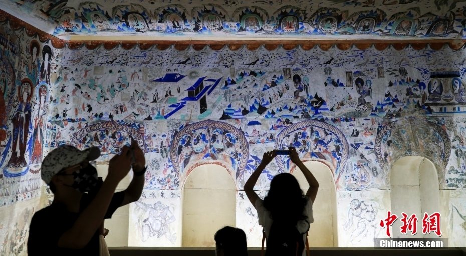 8月30日，“文明的印记——敦煌艺术大展”在北京民生现代美术馆开展。展览从“经典敦煌艺术”“藏经洞专题”“1940年以来的敦煌艺术手法与精神”三大主题出发，共展出复制洞窟8座，文物、临本、现当代艺术家创作等280余组（件），再现了石窟艺术的不朽神韵，展示了敦煌学的博大宏阔，展现了敦煌艺术的现代活力。图为观众参观莫高窟第285窟（整窟原大临摹）。中新社记者 贾天勇 摄