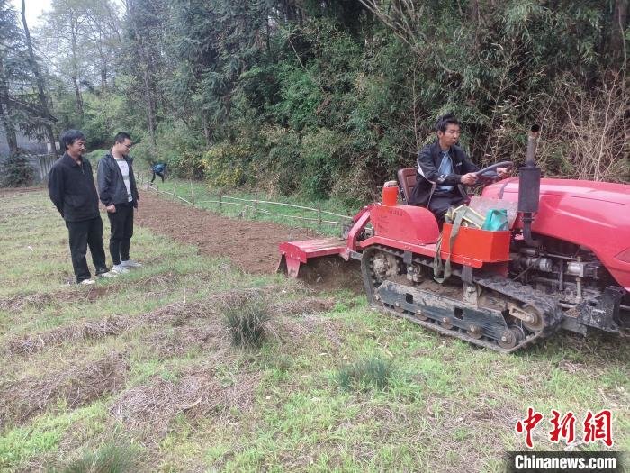 图为修路后村里开展了机械化作业。　段振枢 摄