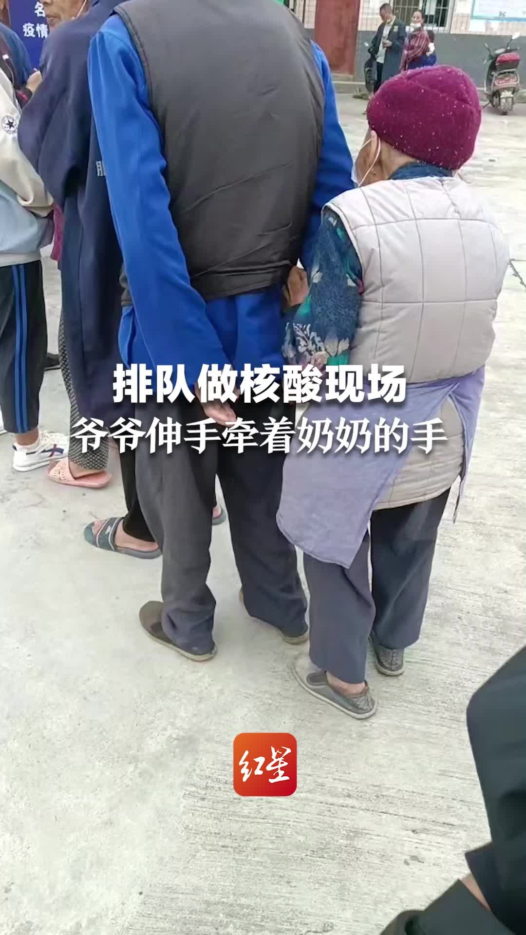 网友拍下排队做核酸温馨一幕，爷爷伸手牵着奶奶的手