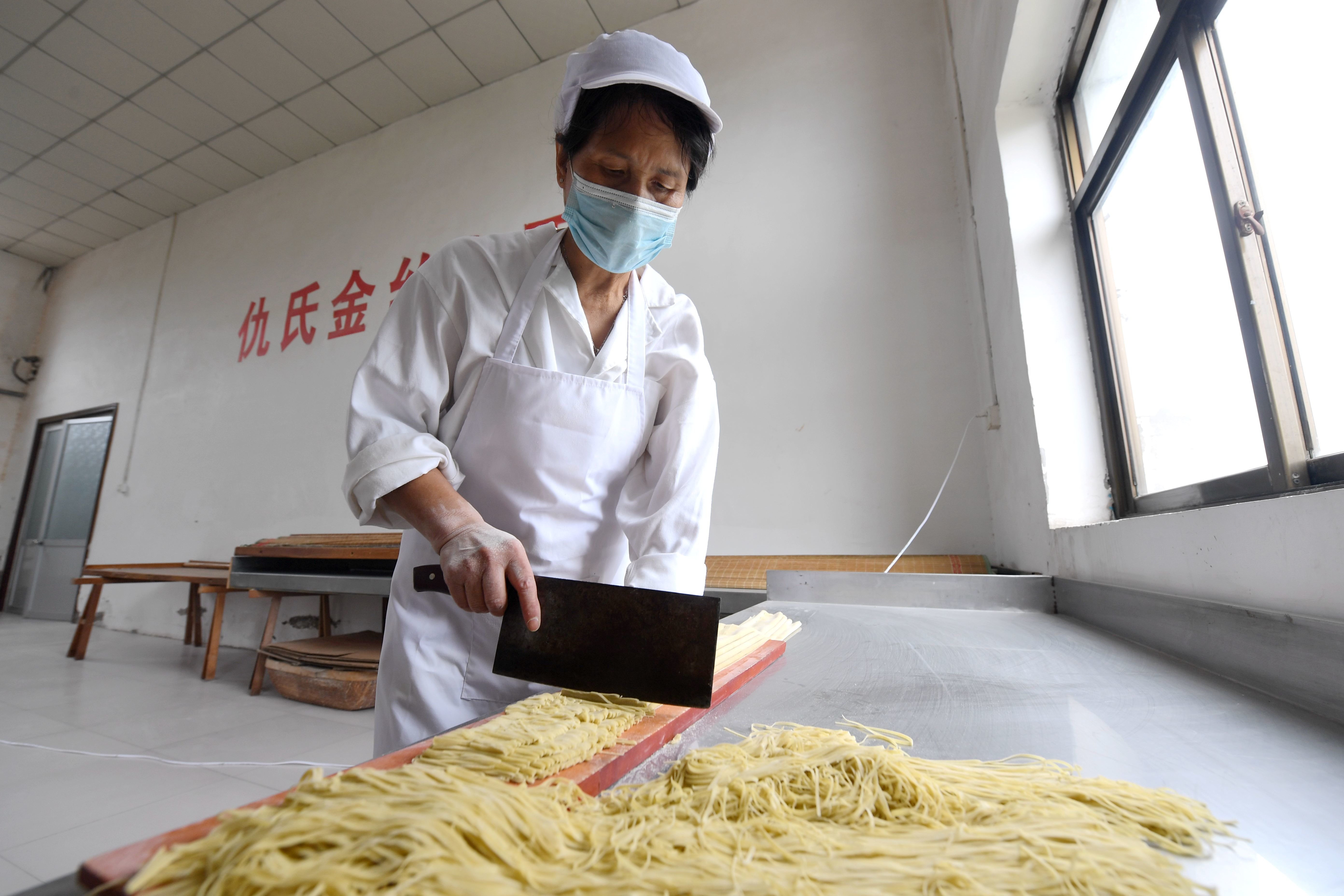 8月30日,饶阳县一家金丝杂面公司的工人在车间内切面.