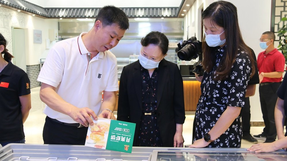 汕头市达濠李老二食品有限公司董事长李耀宏（左一）展示特色产品。（见习记者翁均婷 摄）