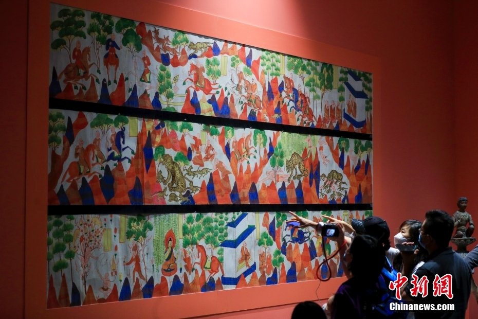 8月30日，“文明的印记——敦煌艺术大展”在北京民生现代美术馆开展。展览从“经典敦煌艺术”“藏经洞专题”“1940年以来的敦煌艺术手法与精神”三大主题出发，共展出复制洞窟8座，文物、临本、现当代艺术家创作等280余组（件），再现了石窟艺术的不朽神韵，展示了敦煌学的博大宏阔，展现了敦煌艺术的现代活力。图为观众参观第428窟《萨埵太子本生故事》（临摹）。中新社记者 贾天勇 摄