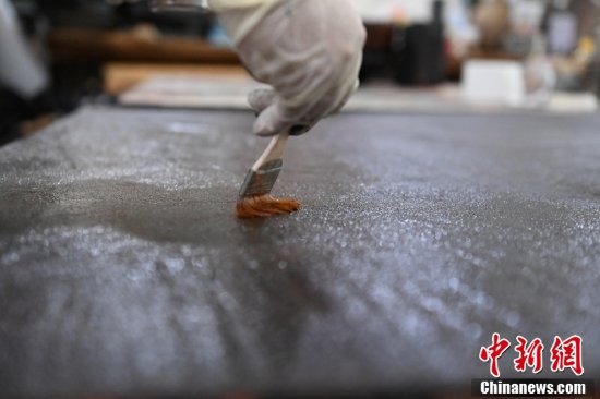 9月2日，甘肃兰州，西北民族大学美术学院学生在漆画工作室内进行刷漆工作。刘志刚表示，他们所创作的漆画内容不少都与敦煌艺术、边塞文化相关联，让大家看到作品后就会有种行走在诗歌中的感受。中新社记者 李亚龙 摄