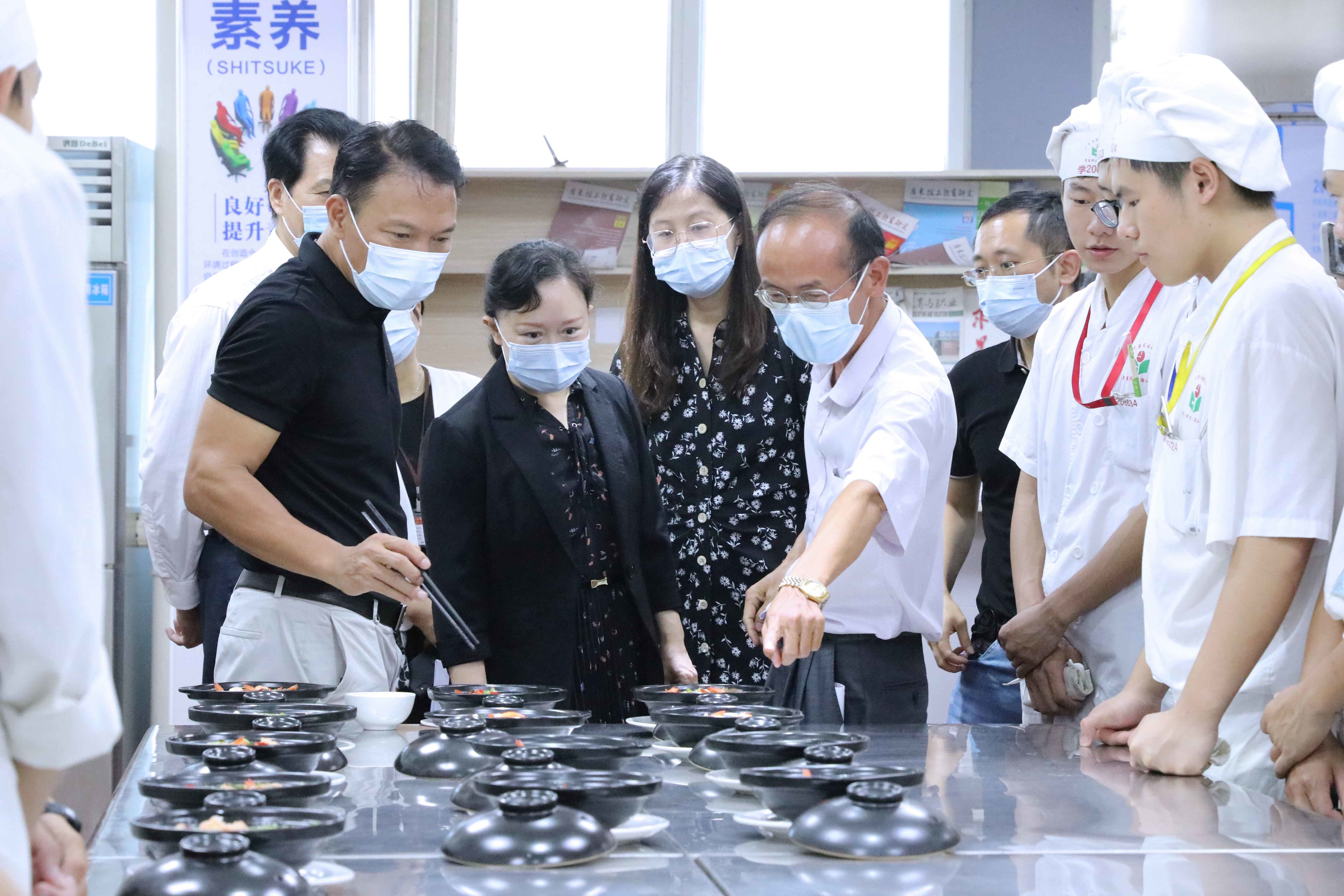 广东省粤东技师学院党委副书记、院长何启谋（左一）介绍“粤菜师傅”工程建设情况。