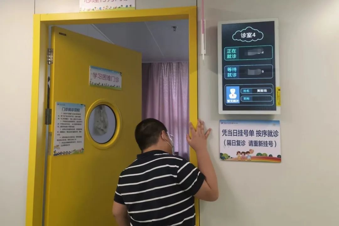 2022年8月16日，一位前来就诊的男孩正在向“学习困难门诊”室内张望。新京报记者 李照 摄