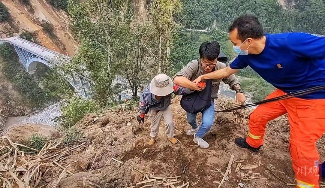 9月6日下午，李柔（左一）和救援人员一起攀爬，前往磨西镇安置点。华小峰 摄影