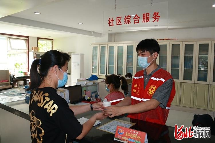 图为山海关区西关街道西河社区“红色驿站”工作人员正在为办事群众办理服务事项。