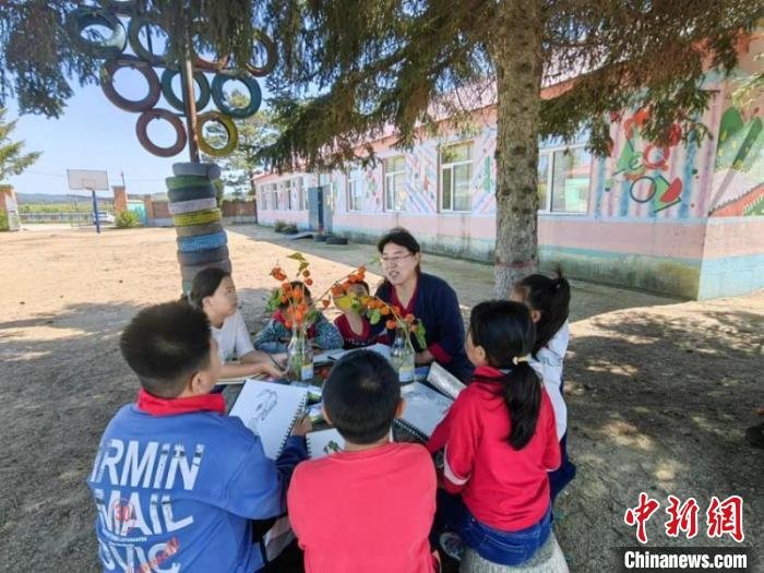 王晓野的在室外给孩子们上美术课 石洪宇 摄