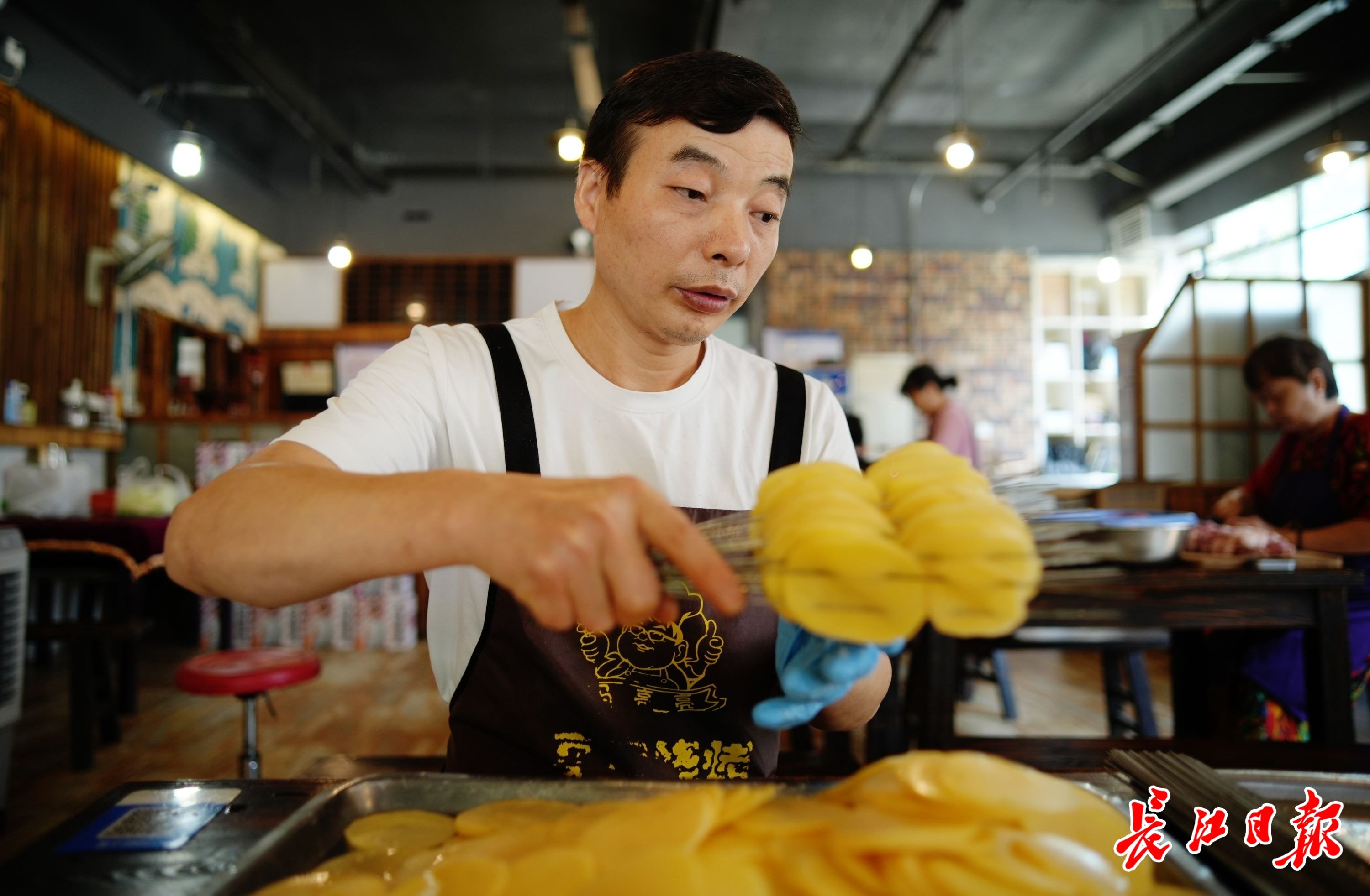 李志成在串土豆片。 记者何晓刚 摄