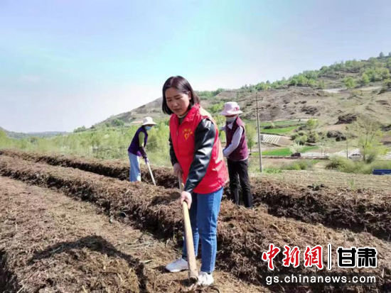 图为甘肃省临夏回族自治州和政县三十里铺镇马家河村妇联主席李巧珍与村民一同干农活