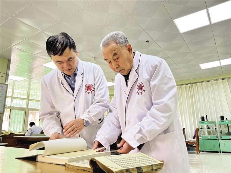师有宽(右)和大徒弟何谋忠讨论修复方案