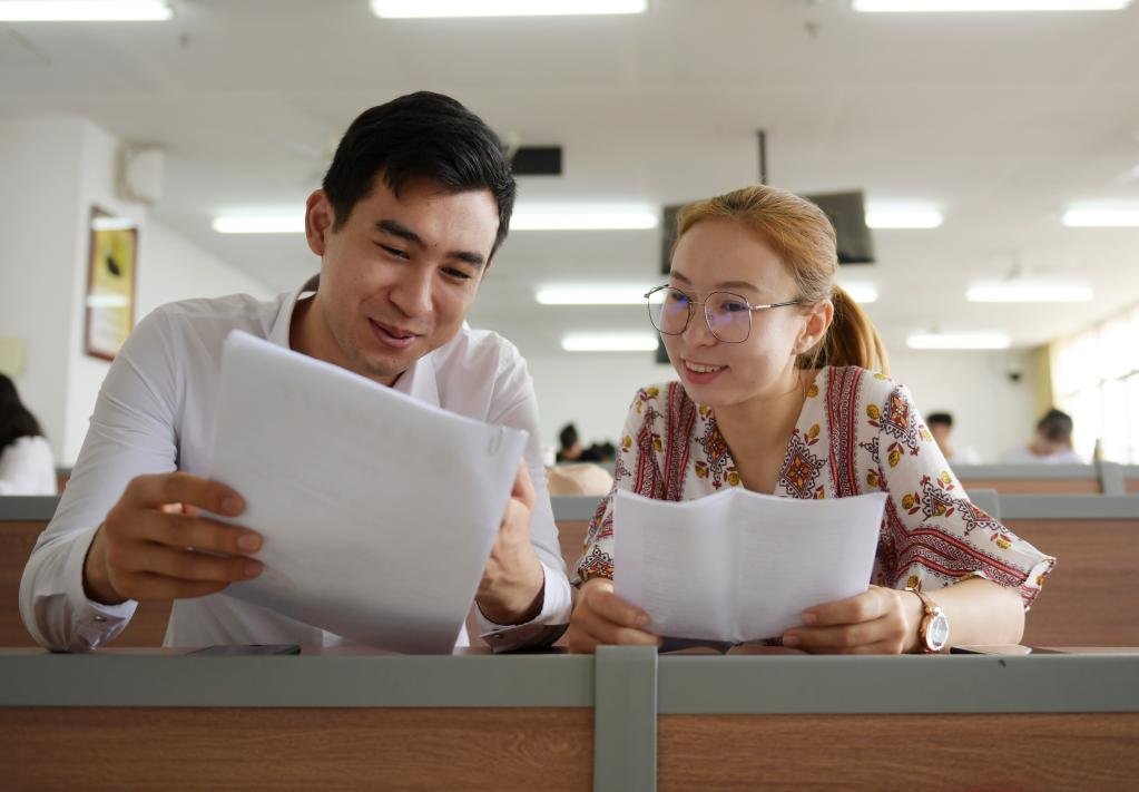 2019年6月10日，陕西中医药大学的哈萨克斯坦留学生马文轩（左）和玲琅在教室里讨论他们的针灸推拿学毕业论文。新华社记者 李一博 摄