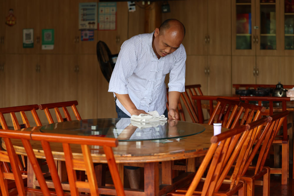 在湖南省湘西土家族苗族自治州十八洞村，杨正邦在自家农家乐打扫卫生（2022年7月2日摄）。新华社记者 薛宇舸 摄