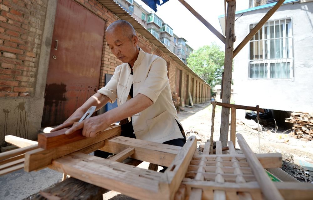 2015年时的李树森在制作微缩农具 新华社记者 李一博 摄