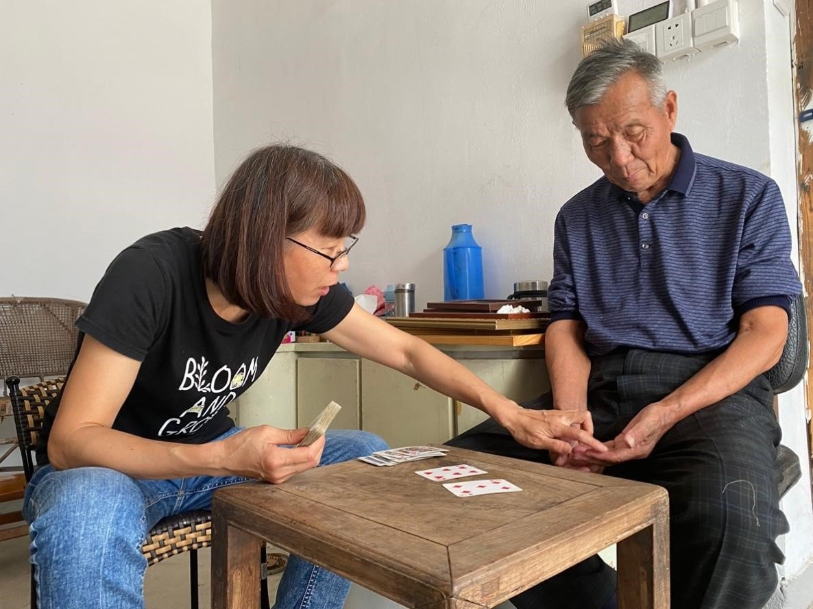 小女儿在用扑克牌教爸爸算数，做认知训练，以延缓病情。澎湃新闻记者 李季 图