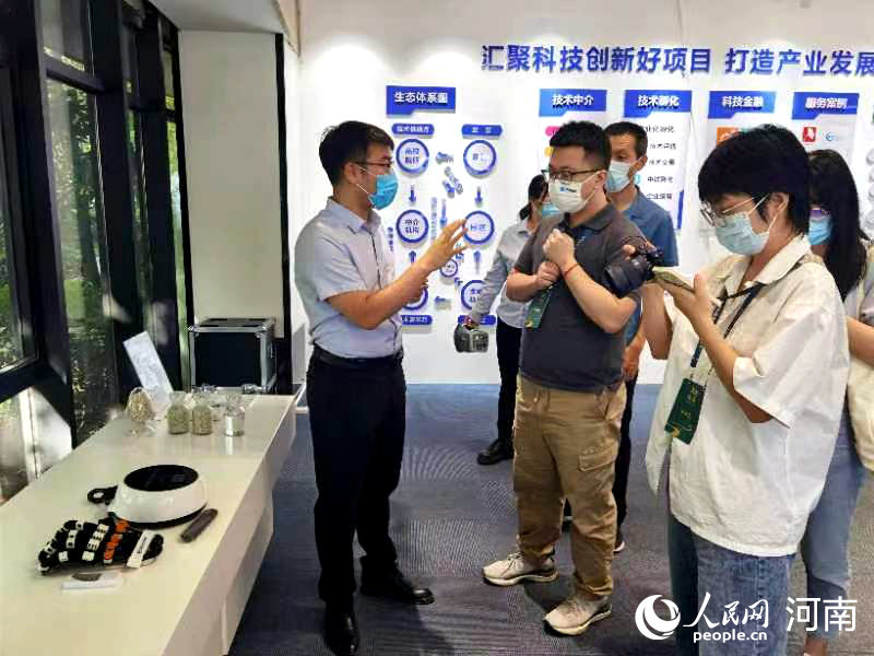 洛阳国家大学科技园产业发展中心主任郭吉伟向记者介绍创新项目。人民网 程明辉摄