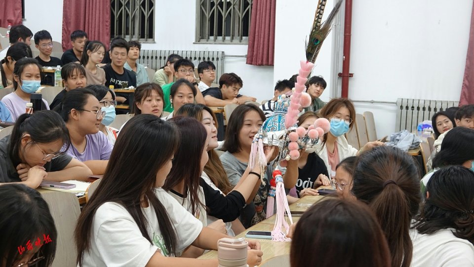 摸着翎子帽，学生们爱不释手。