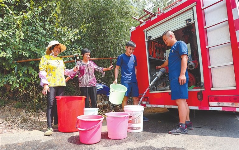 在瑞昌市范镇开源村，消防员们临时组建送水小分队，让每一名群众都能喝上干净水。 （特约通讯员 魏东升 摄）