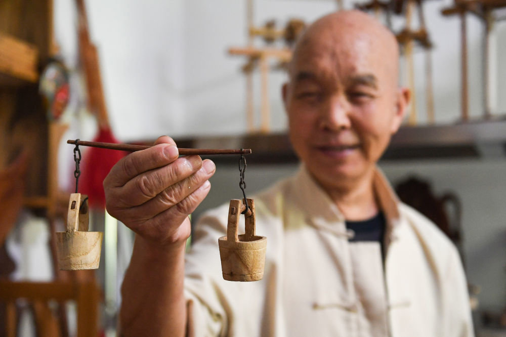 李树森在展示自己制作的微缩农具 新华社记者邹竞一摄