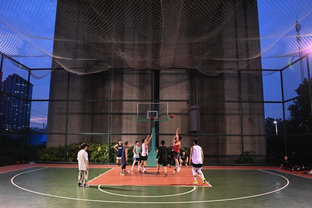 杭州市民在位于高铁桥下的钱江世纪城体育公园打篮球。在杭州，一批运动场馆见缝插针地“嵌入”市民生活圈，城市空间的“边角余料”正成为全民健身的“金角银边”。新华社记者 黄宗治 摄