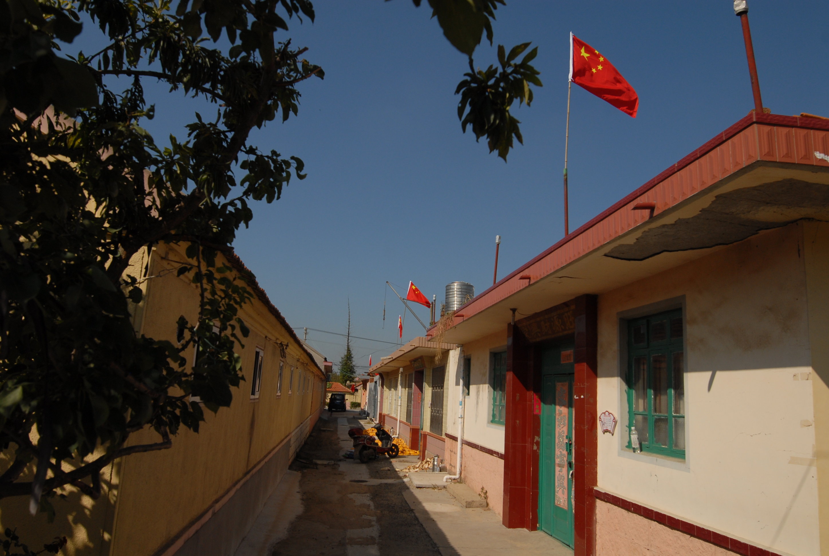 9月30日，山东省青岛市即墨区移风店镇小欧戈庄村的小巷悬挂起鲜艳的国旗。