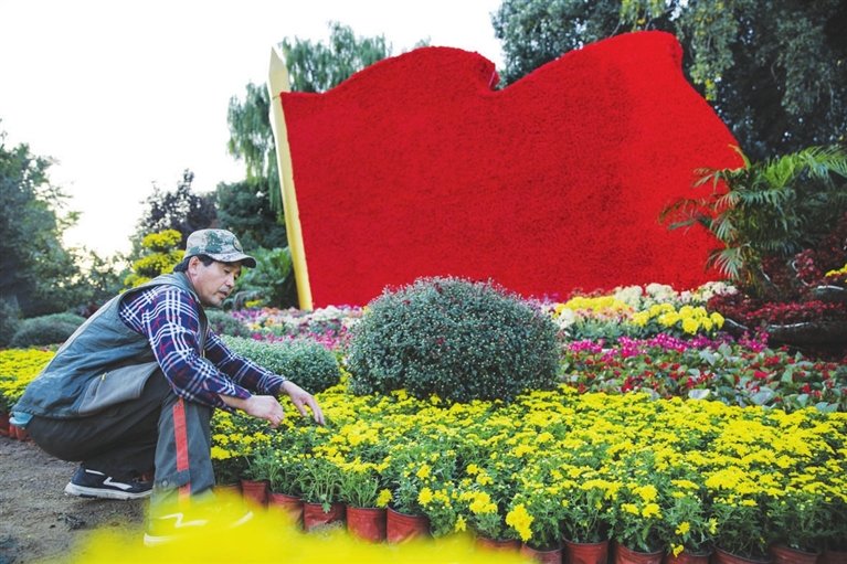 国庆节临近，太原市国旗飘扬、花团锦簇，节日氛围愈加浓厚。9月27日，园林工人正在迎泽桥东搭建立体景观国庆花卉。太原晚报 王韵菲 摄