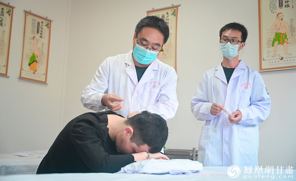 中国甘肃网记者田洋(左)体验皇甫谧针灸术 杨艺锴 摄