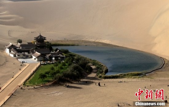 10月4日，游客在甘肃省敦煌市鸣沙山月牙泉景区游览。金秋时节，甘肃省敦煌市鸣沙山月牙泉景区风景宜人，秋色如画，美不胜收。