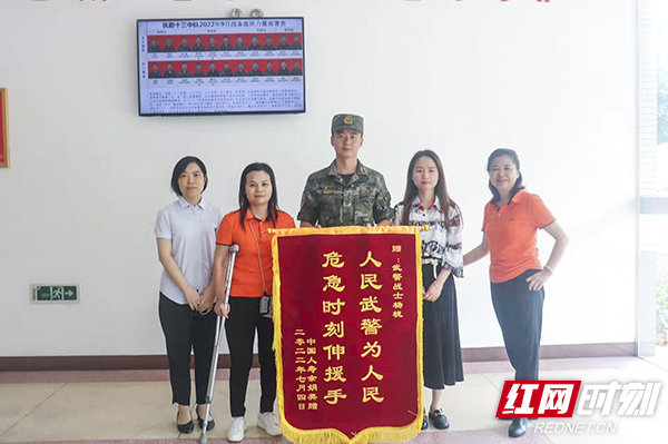 余女士将锦旗送到杨栊手中。