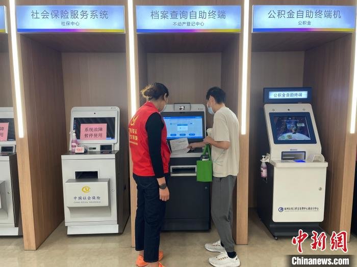 办事人员在志愿者引导下办理业务。　张煜欢 摄