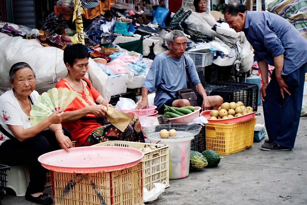 四川省南充市伏虎镇集市上，许多老年人摆摊在路边售卖自己种的农产品。受访者供图