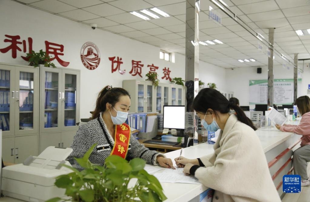 河北省邢台市襄都区宴家屯镇综合服务中心工作人员协助办事群众填写相关表格（2022年3月30日摄）。新华社发（张驰 摄）
