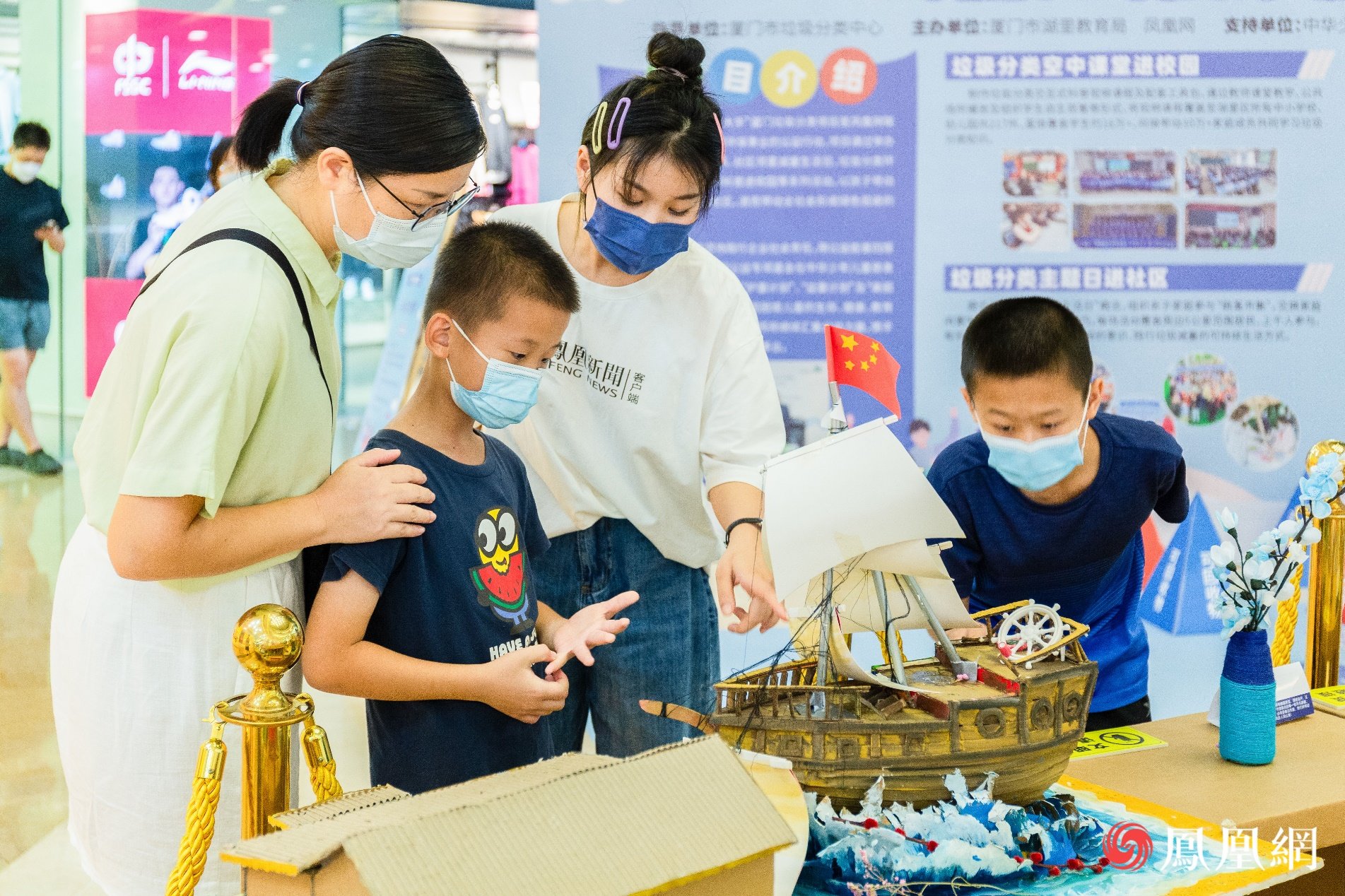 志愿者向观众介绍利用快递盒子做成的帆船