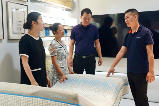 喜临门展厅里工作人员在介绍智能床垫