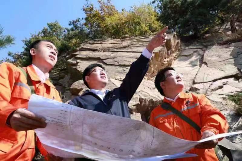 (第六地质大队党委书记、大队长丁正江与队员一同开展野外地质考察)